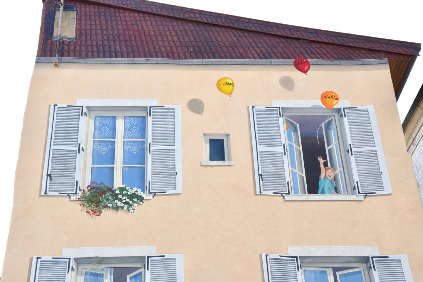 2ème étage avec fenêtres et toiture en trompe-l'oeil sur une façade située à Moirans-en-Montagne 39.