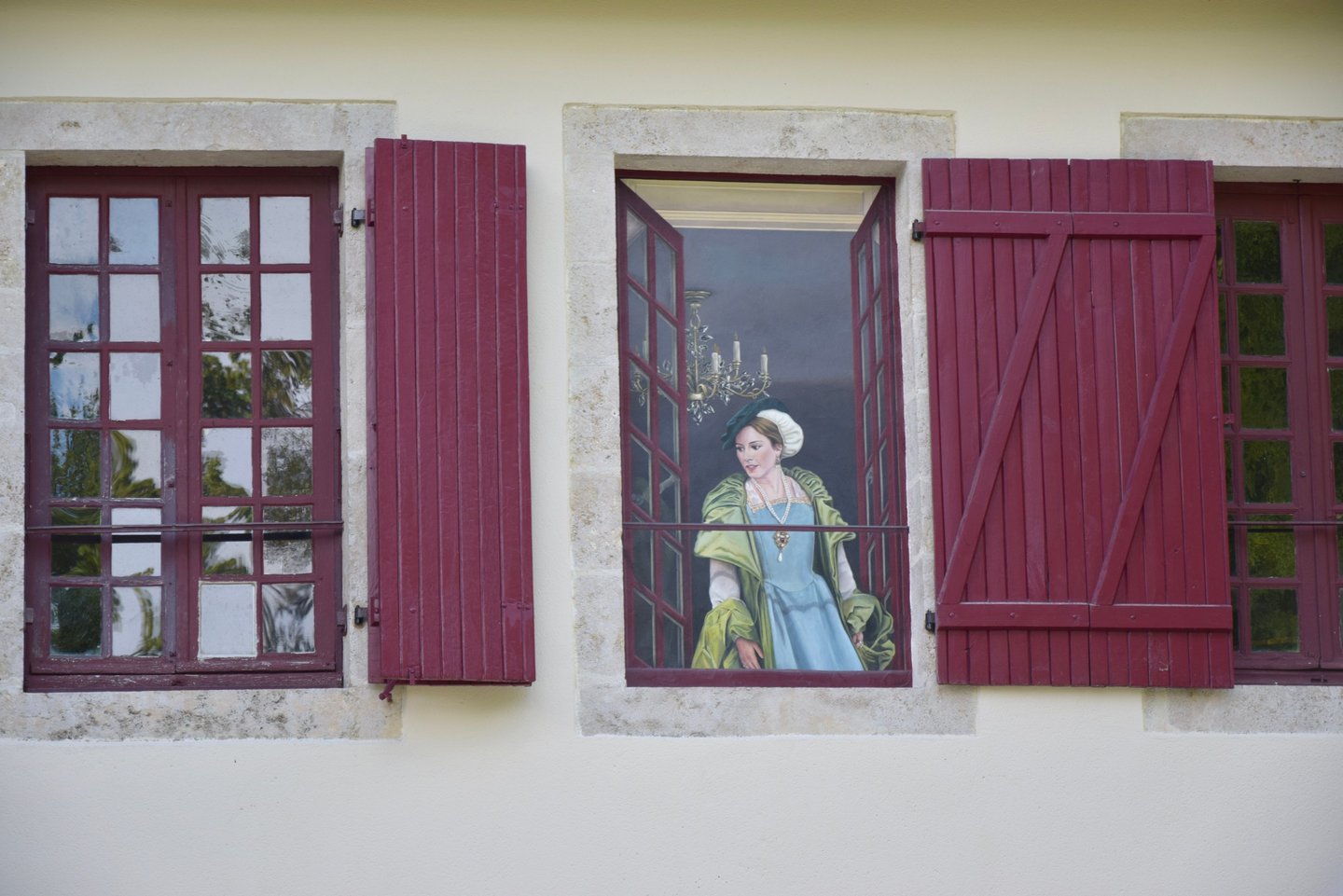 Trompe-l'oeil peint sur une fenêtre murée, personnage en costume d'époque à une fenêtre ouverte.