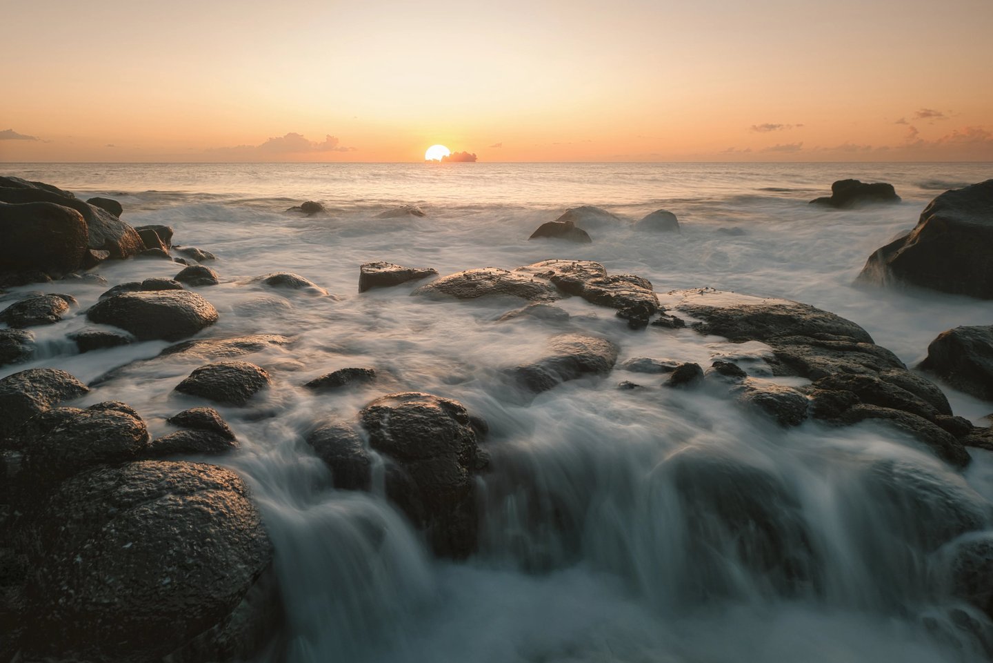 Sunrise over ocean waves on rocky shores in Albion, Mauritius