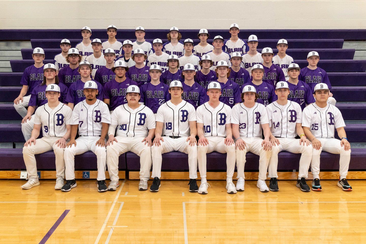 Blair high school baseball team posing for a formal group portrait on gym bleachers.