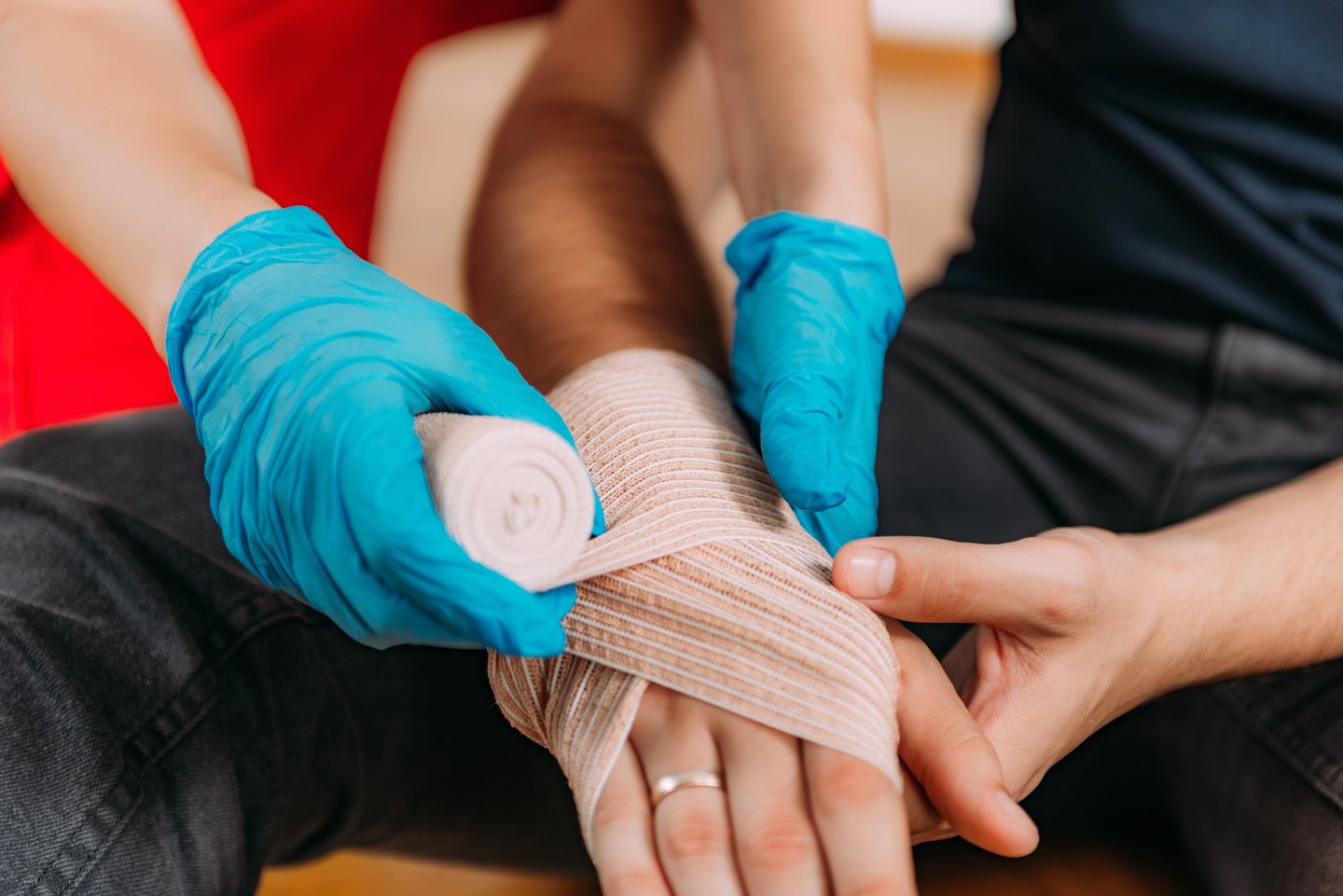 Close up image of a person bandaging someone's hand