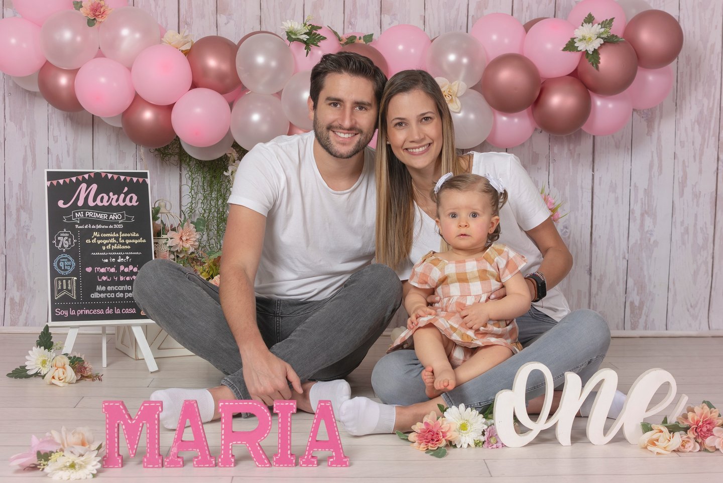 a man and woman sitting on a floor with balloons