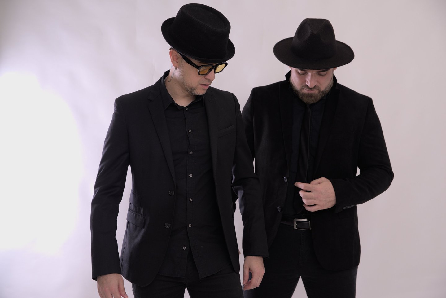 two men in suits and hats standing next to each other