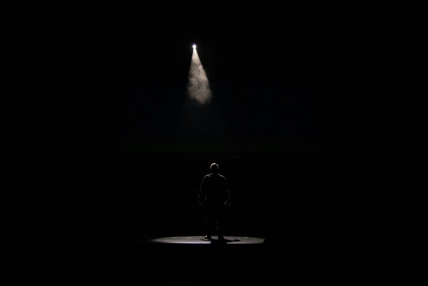 a man standing in front of a spotlight light