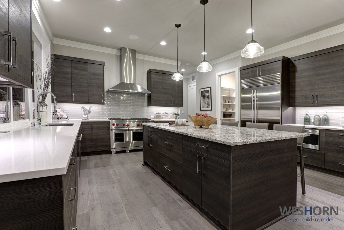 Sleek kitchen featuring dark wood cabinets and stainless steel appliances.