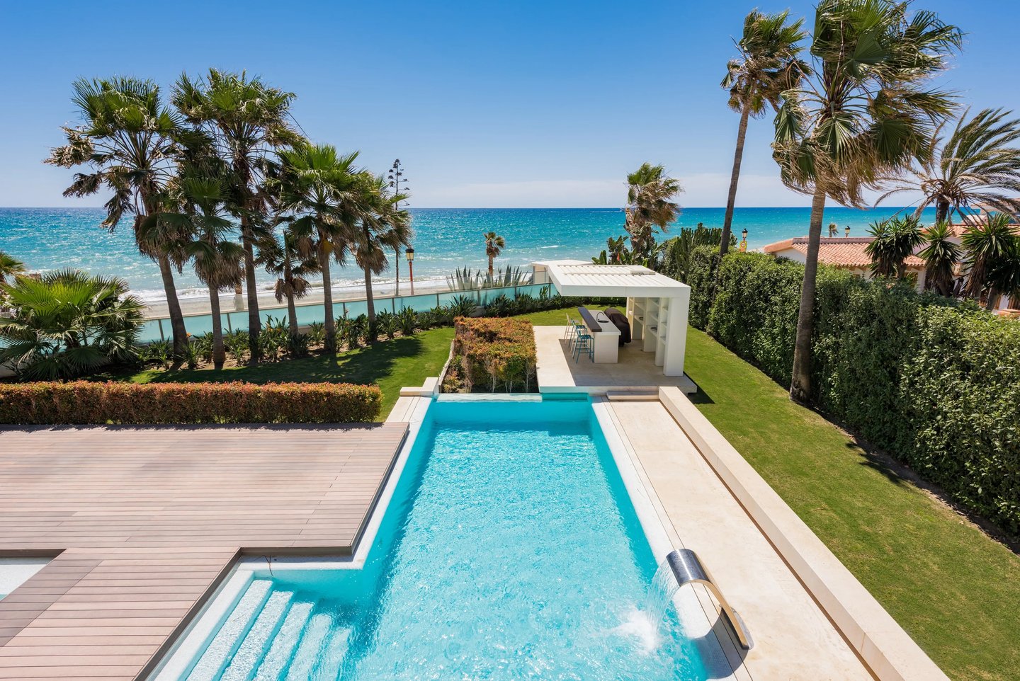 Beachfront pool and garden with outdoor bar pavilion