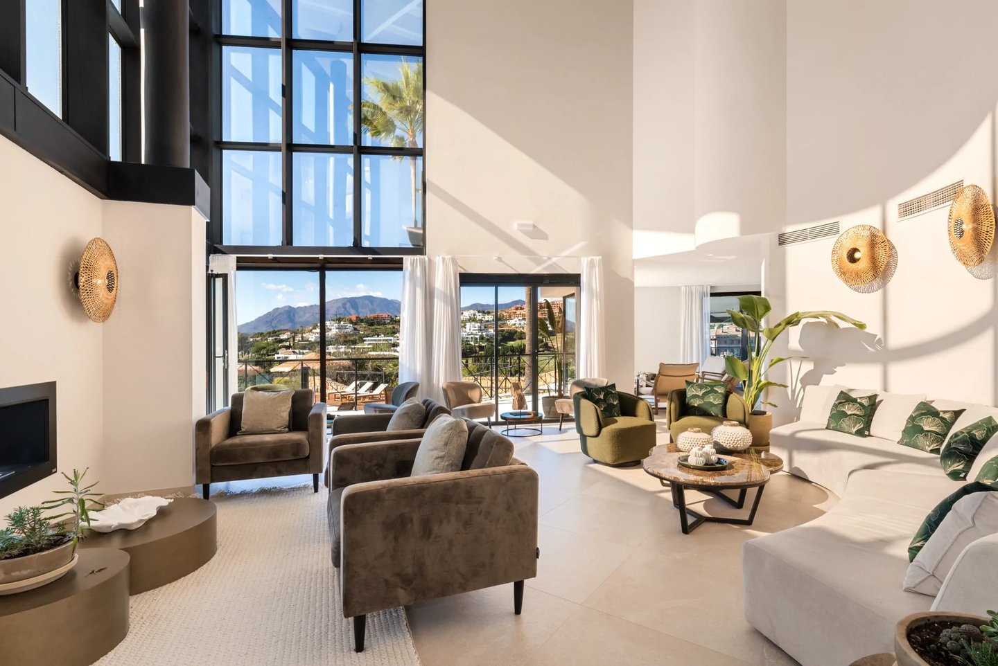 Double height living room with fireplace and terrace views