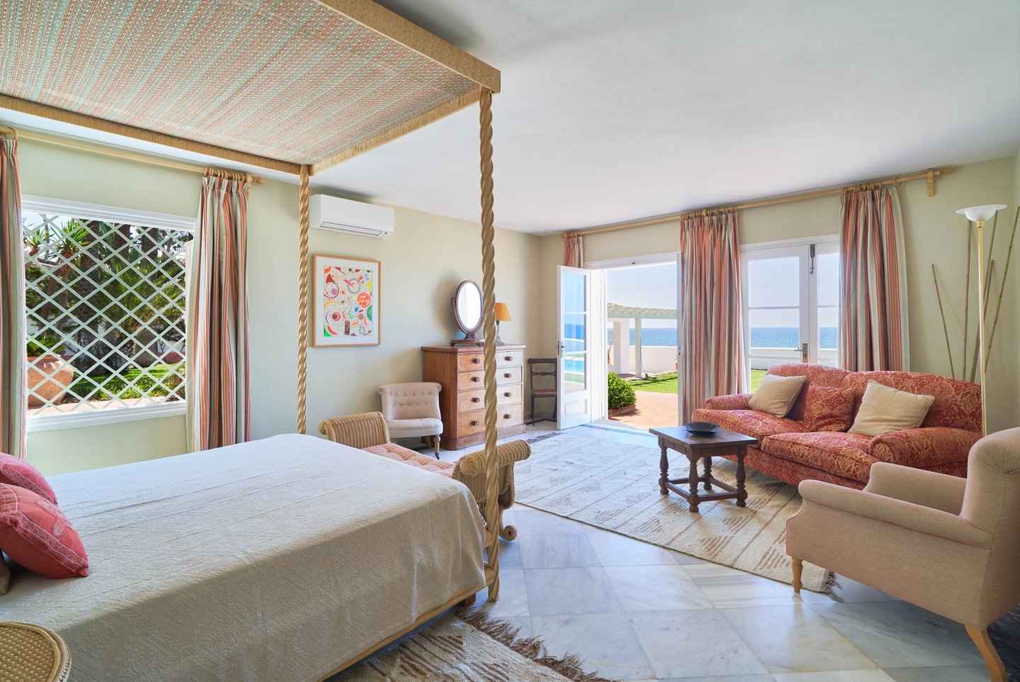Bright bedroom suite with sea views and seating