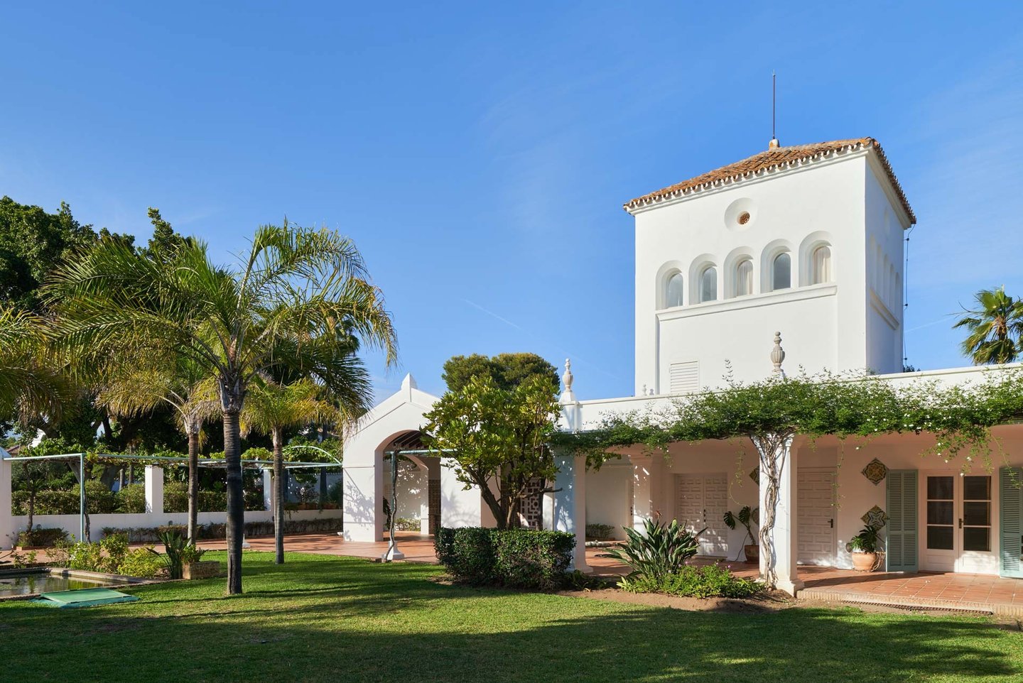 Andalusian villa façade with tower and gardens