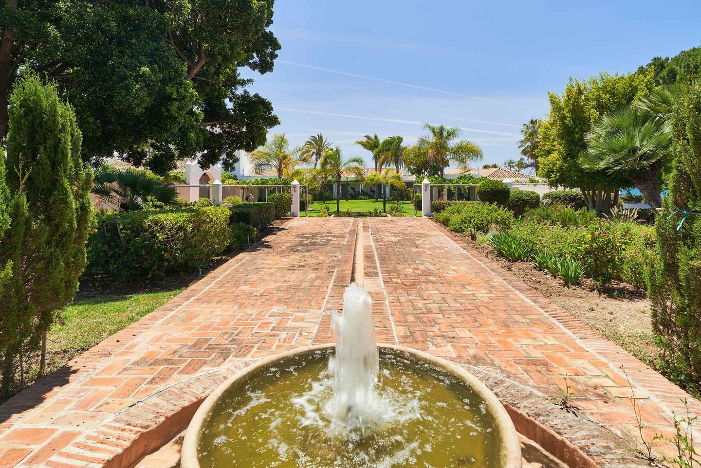Brick pathway with fountain leading to beachfront villa