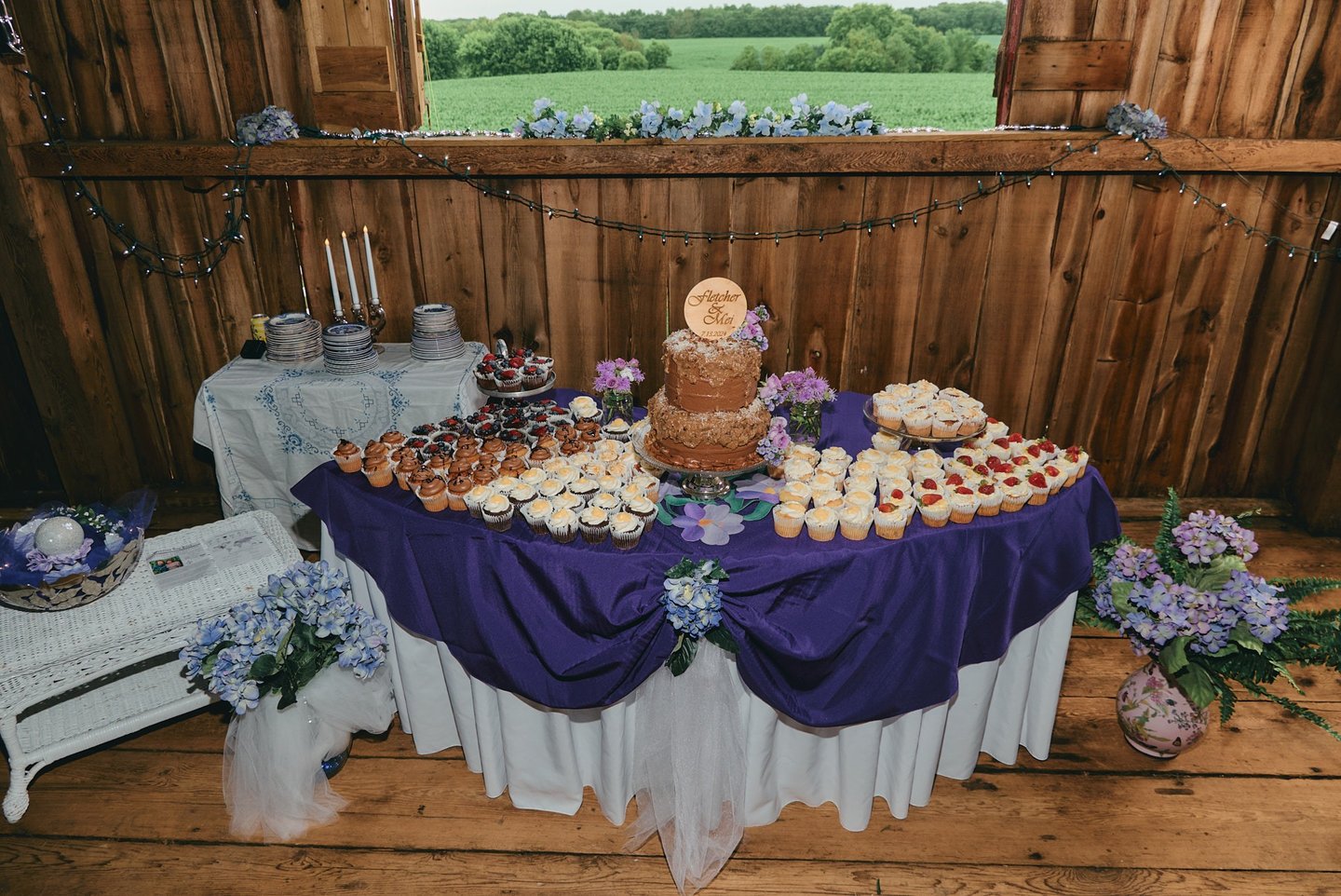 a table with a wedding cake and cupcakes on it