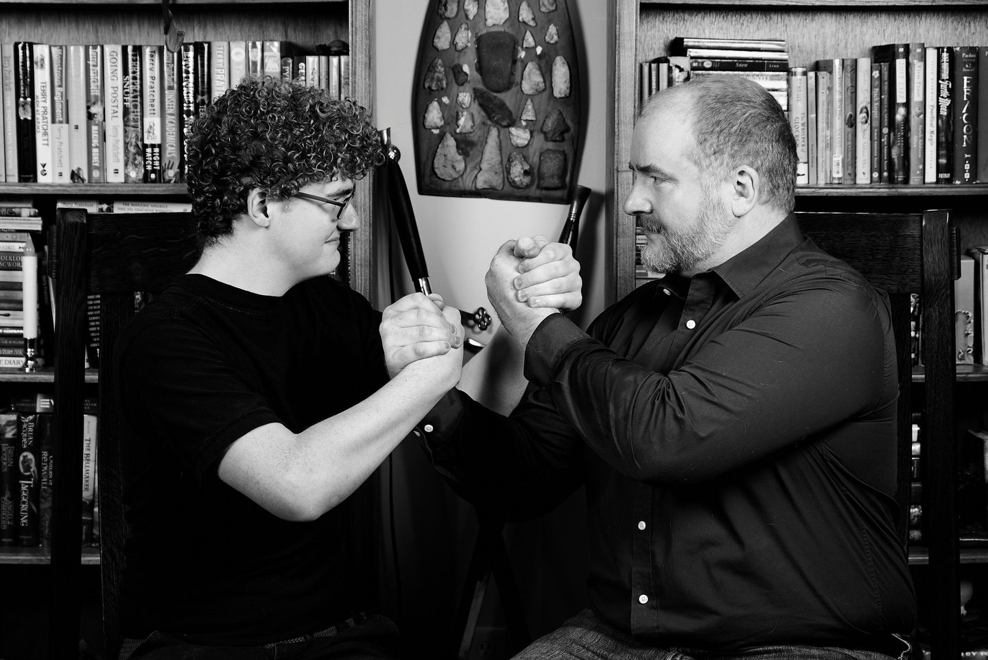 a father and a son are holding hands tight looking at each other in a library