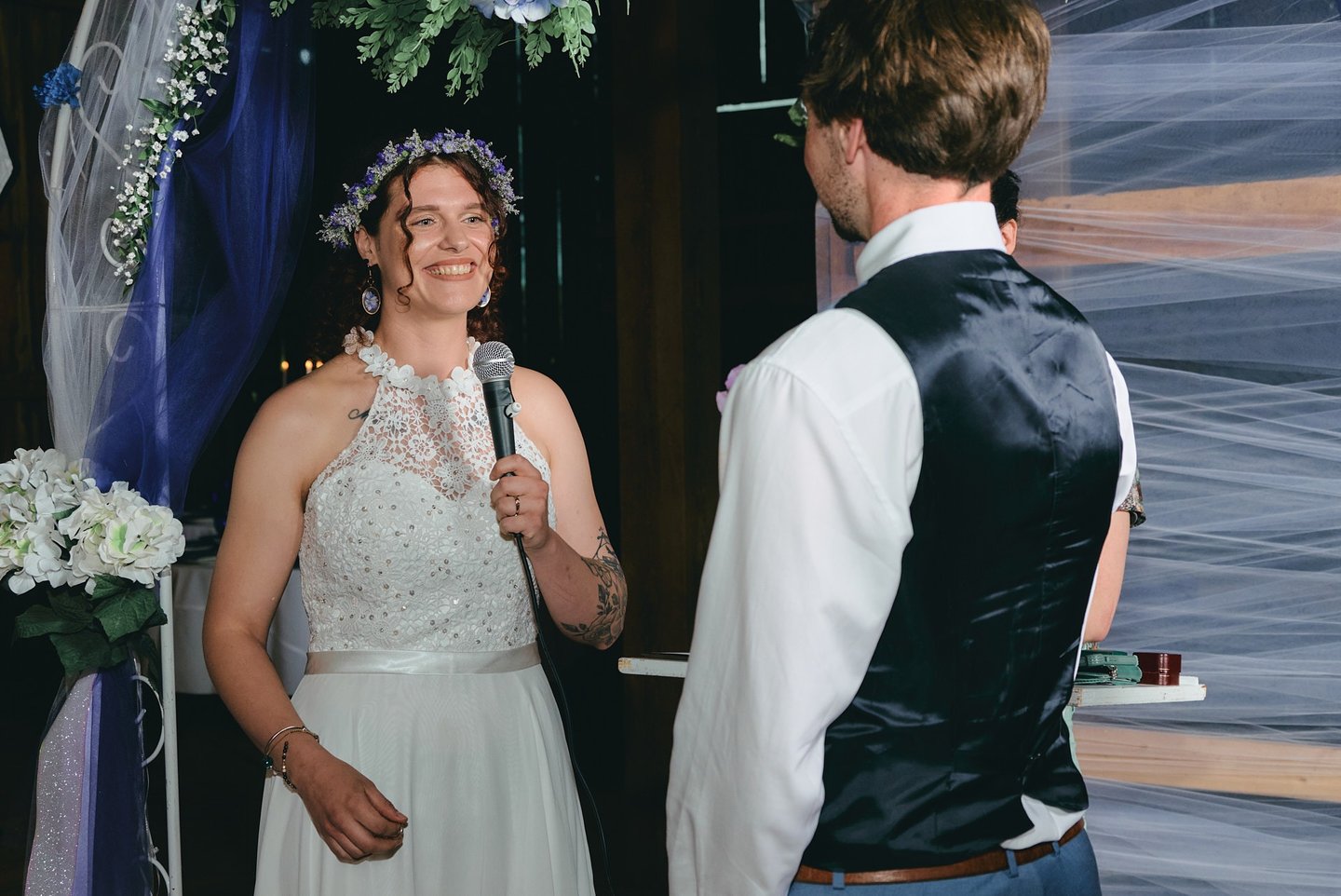 a bride holding a microphone giving a speech to the groom