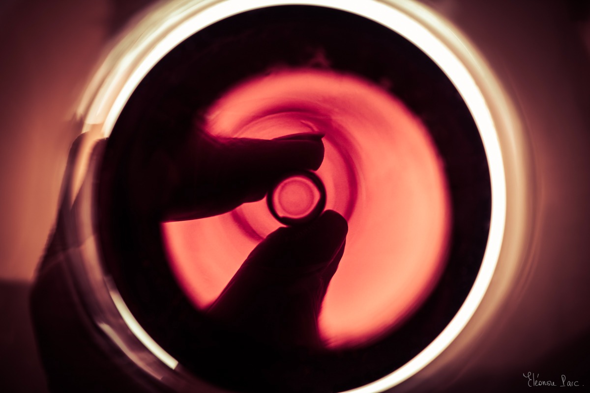 Main rétroéclairée tenant le peid d'un verre de vin