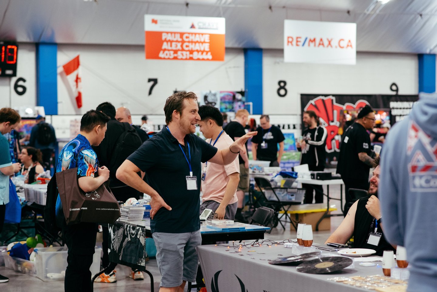 A volunteer smiles and gestures as he excitedly talks with a vendor at the event