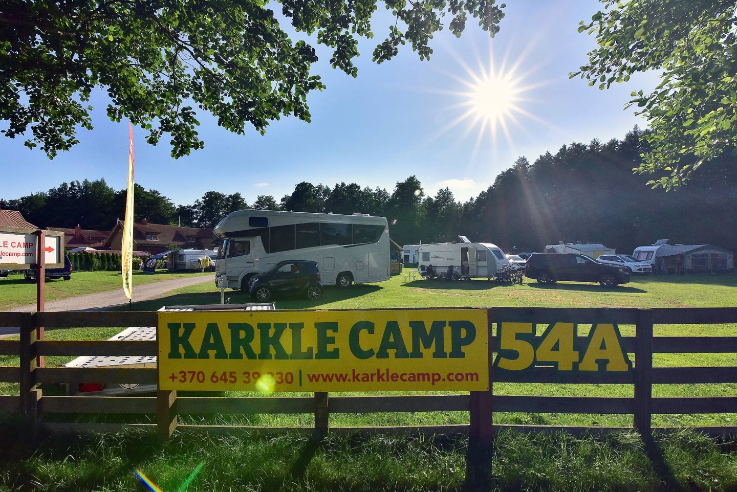 Sunny motorhome and caravan campsite at Karkle Camp under a bright blue sky.