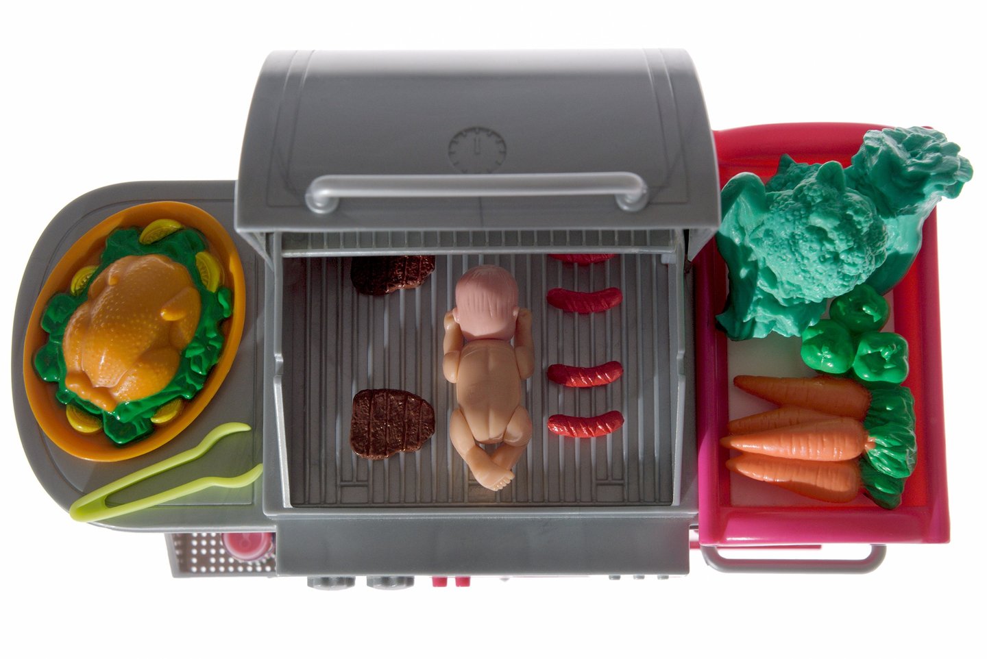 a toy kitchen with a grill and vegetables