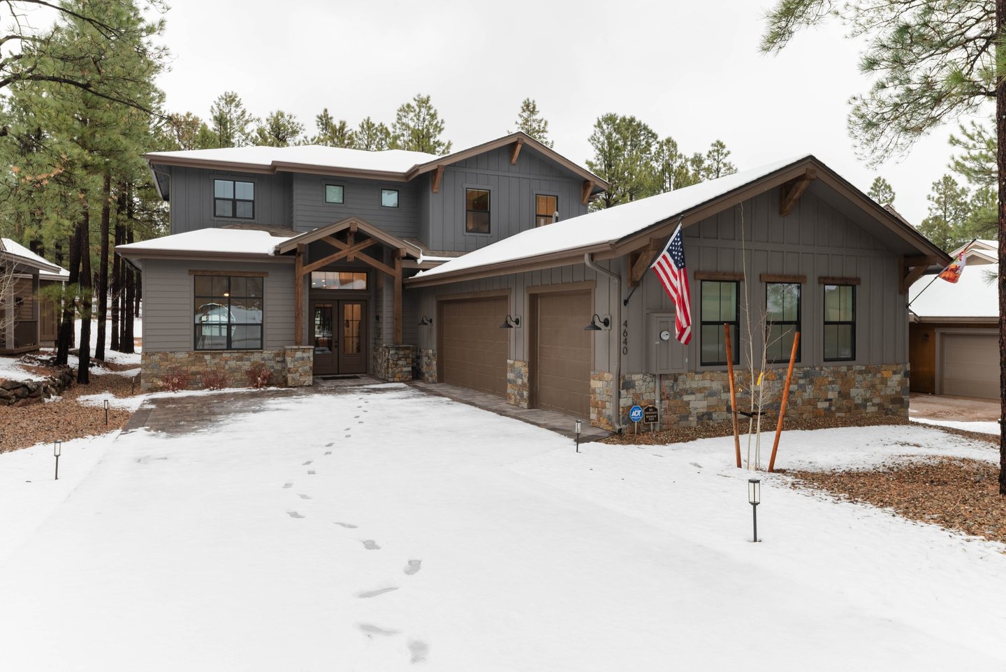 custom home with large garage and snowy driveway