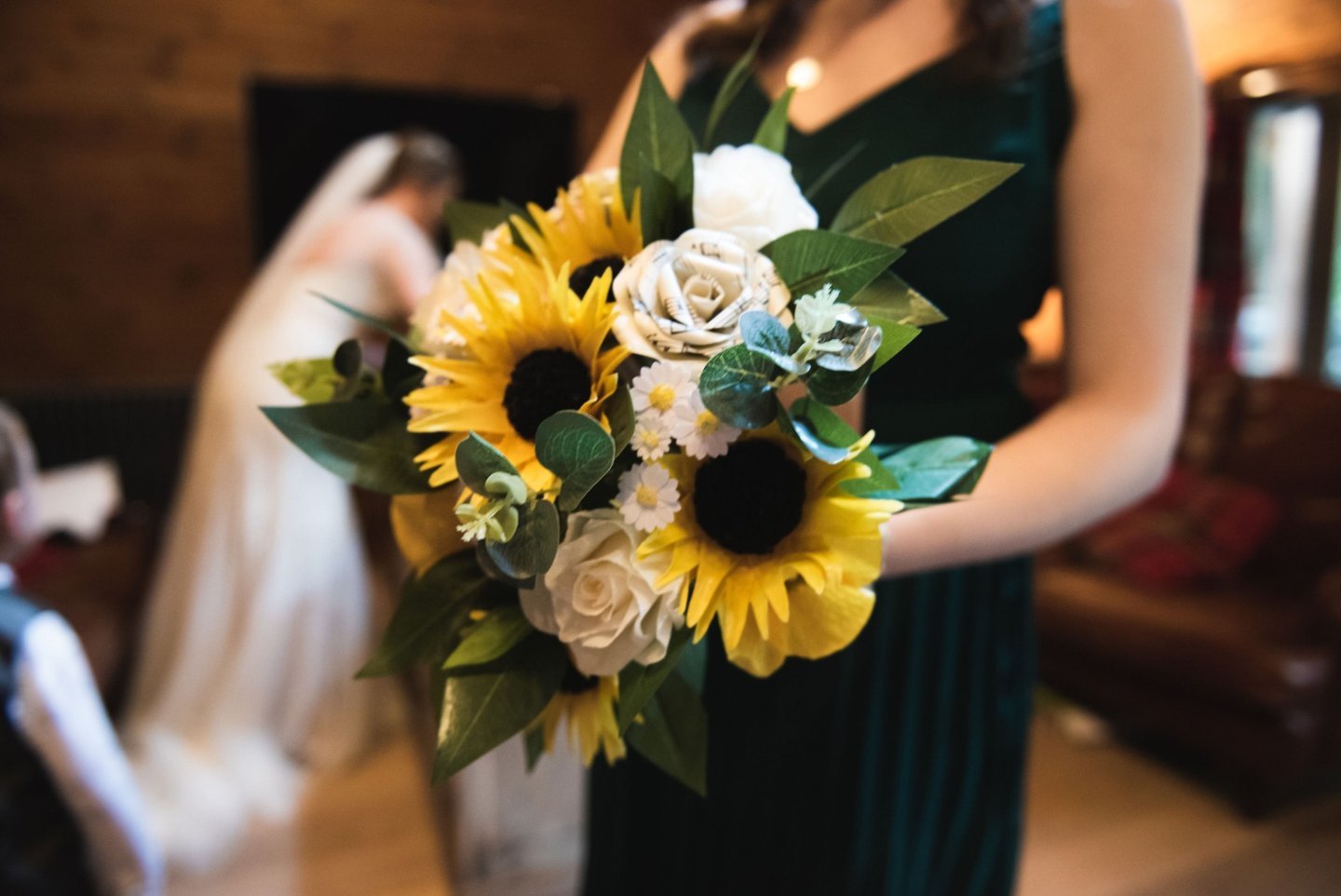 a woman in a green dress holding a bouquet of wedding flowers