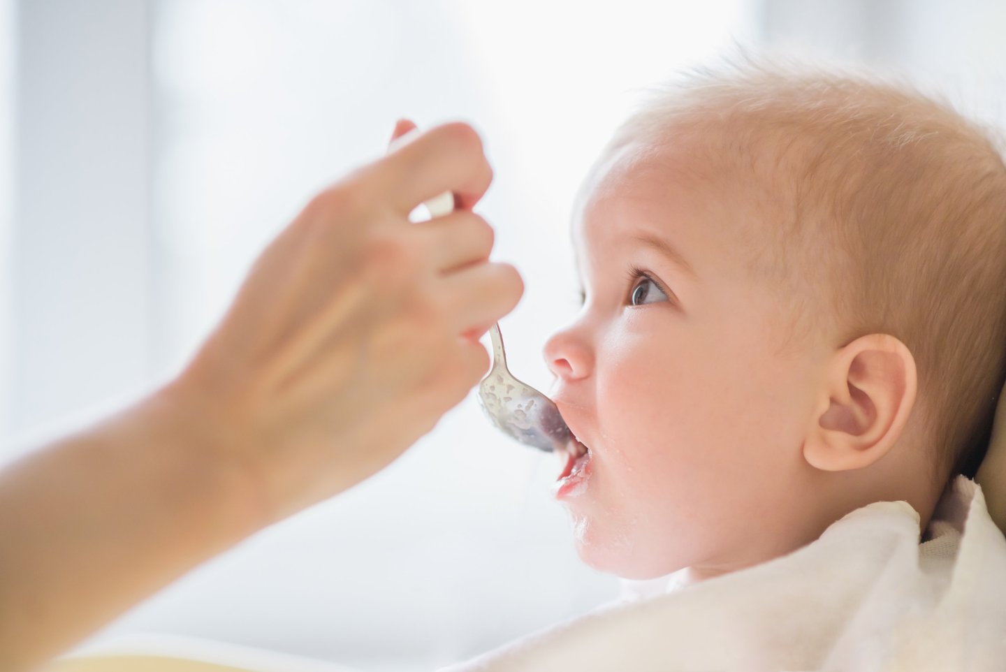 a baby gets food from a spoon