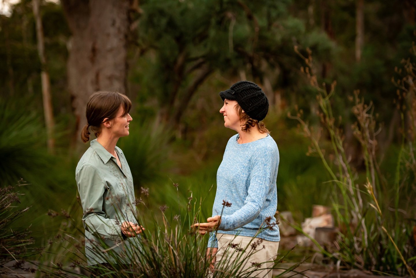 Joanna talking to a gardening client while looking at a native plant