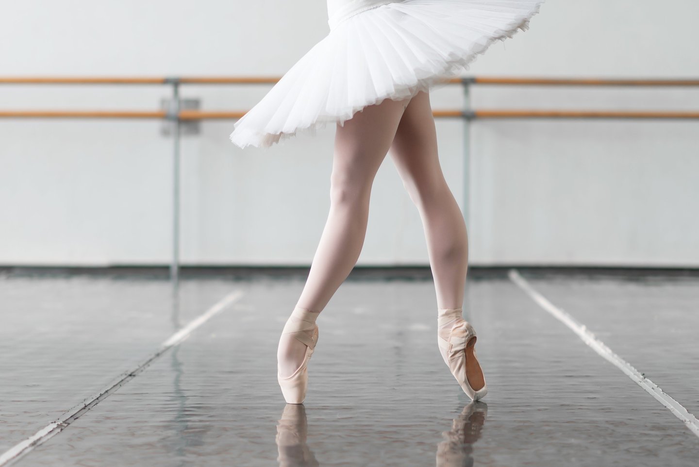a ballerina in a white dress and a ballet shoe