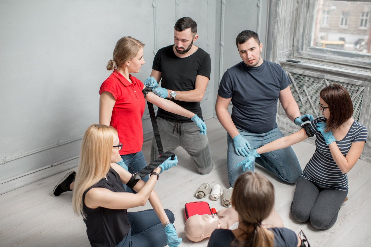 People sitting in a classroom learning how to apply a tourniquet