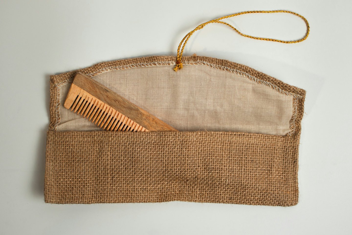 Photo of a wooden comb in a burlap purse. Credit Raghavendra V. Konkathi via Unsplash.