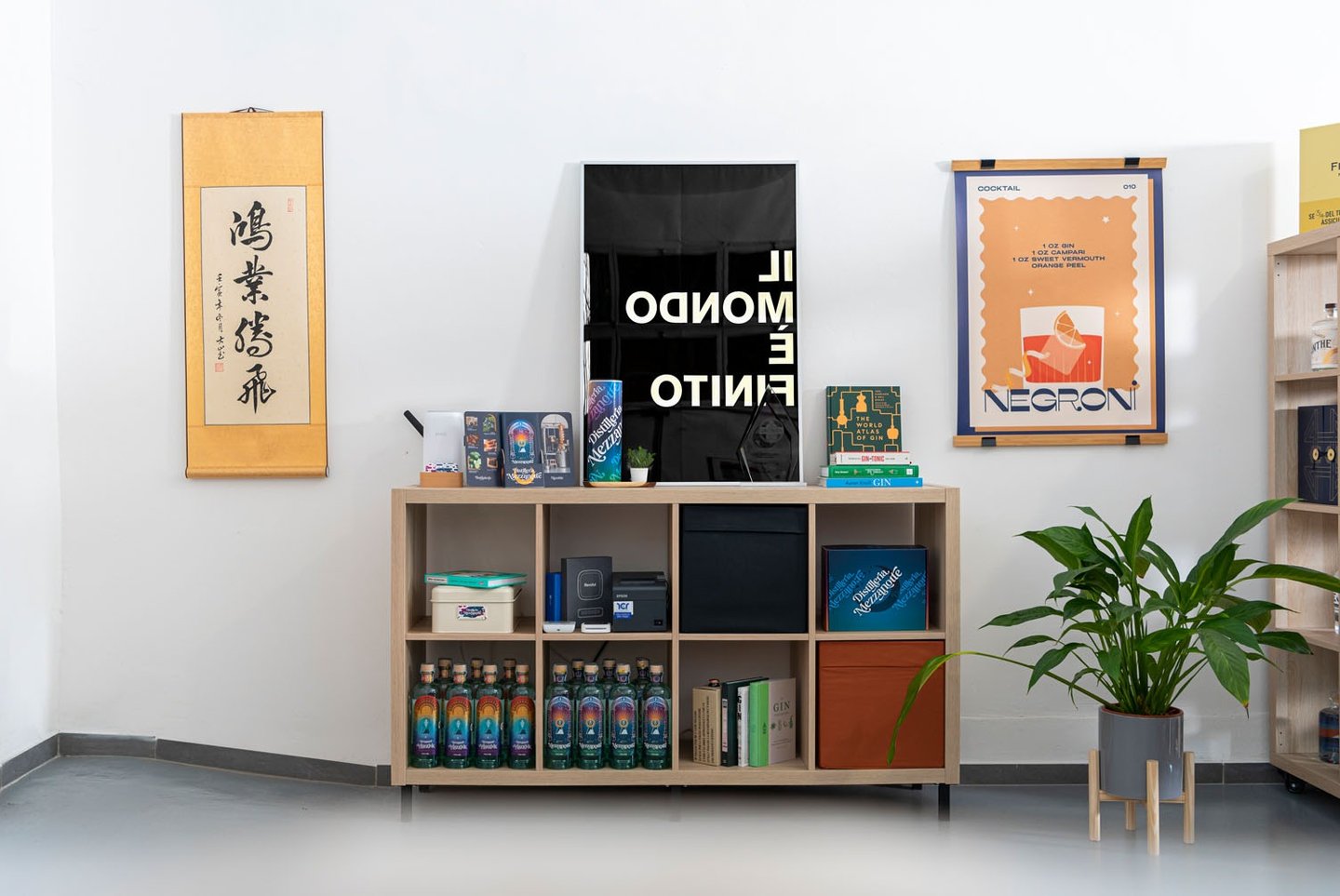 Mobile con bottiglie di Gin, appoggiate sopra e quadri appesi alla parete