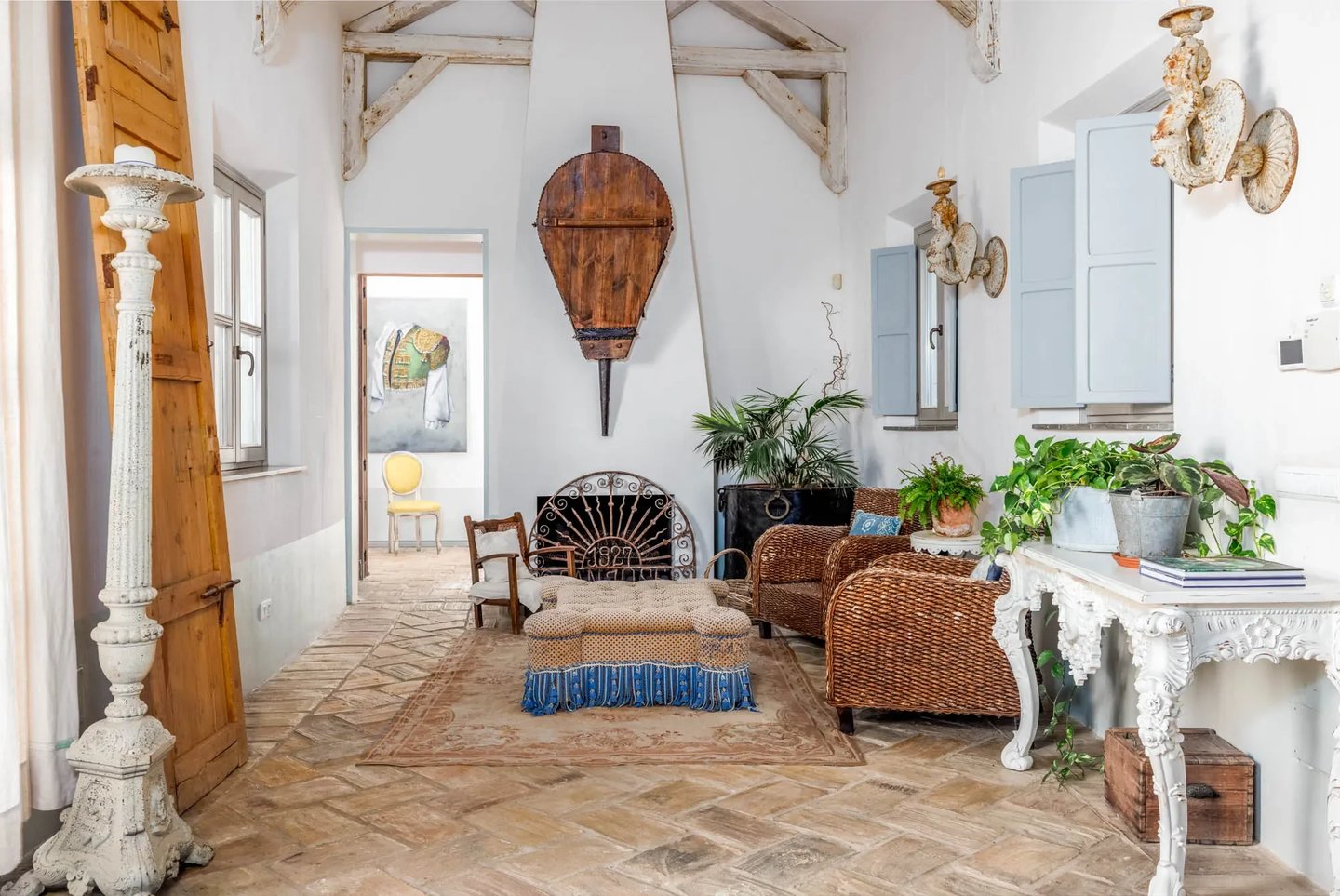 Rustic lounge with wicker chairs and fireplace at Finca Santa Katerina