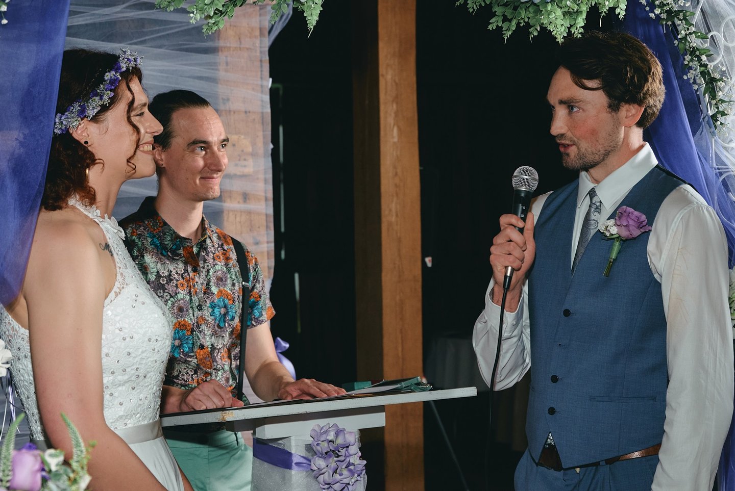 a groom holding a microphone giving a speech to the bride