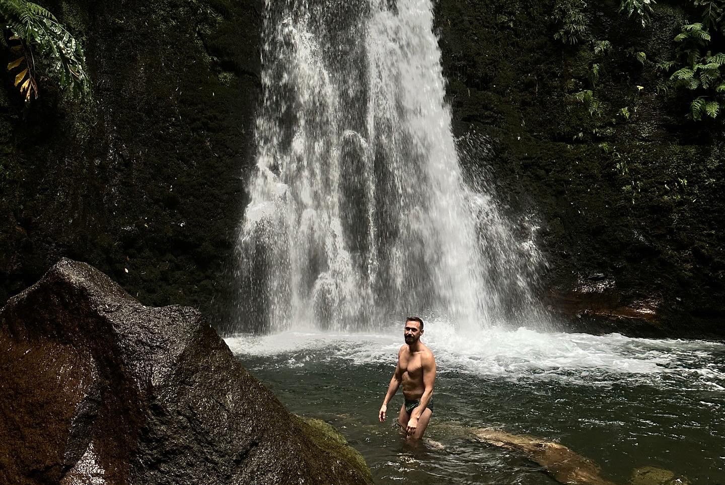 Gay man in waterfall at azores queer retreat