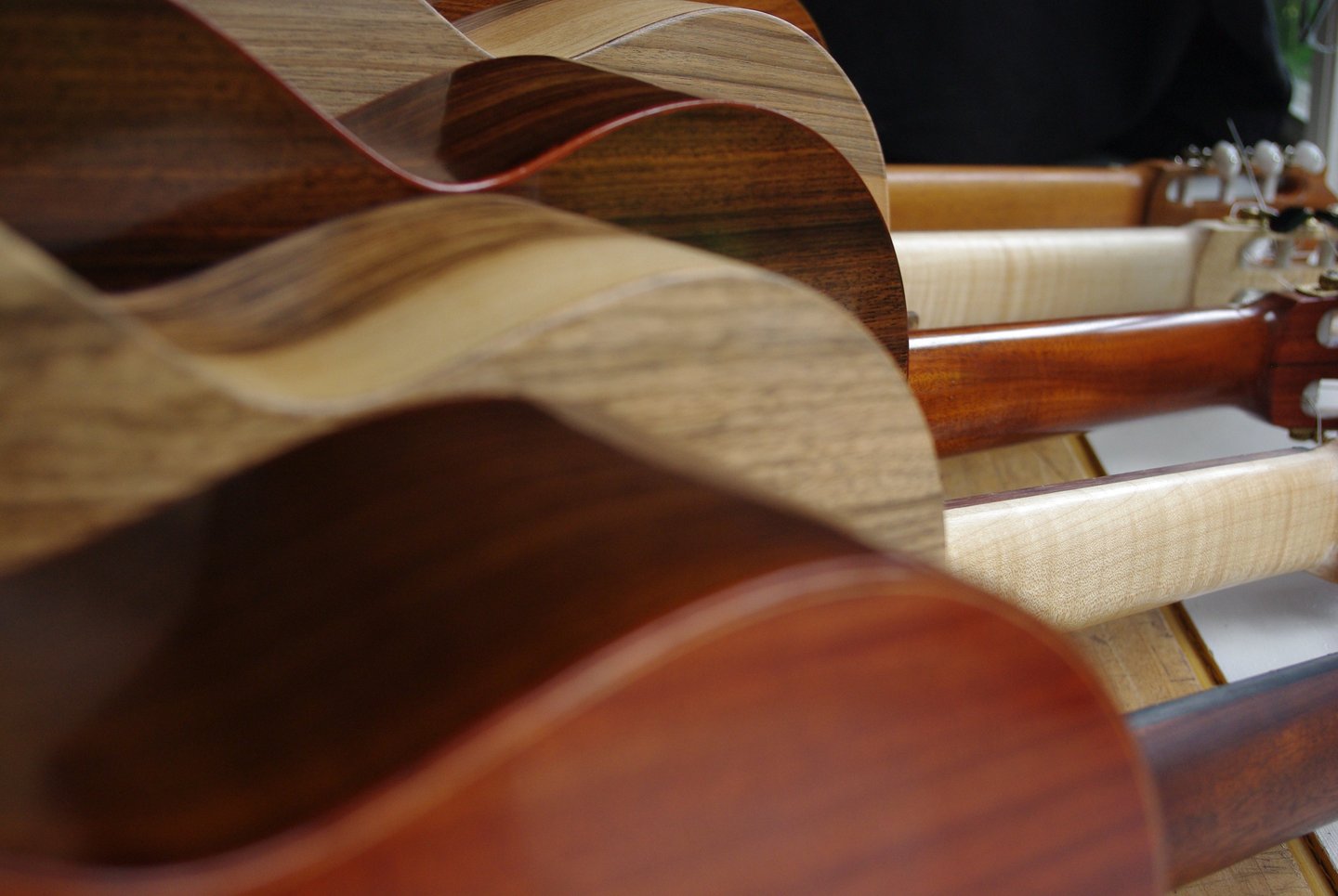 Close-up view of handcrafted wooden guitars master grade tonewoods and headstocks.