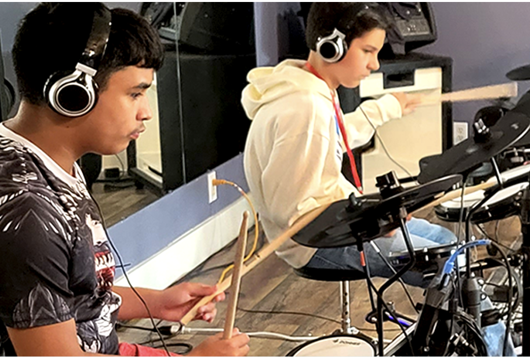 Teens drumming on electric drums