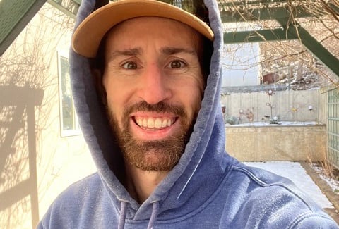 a man in a blue hoodie and a hat