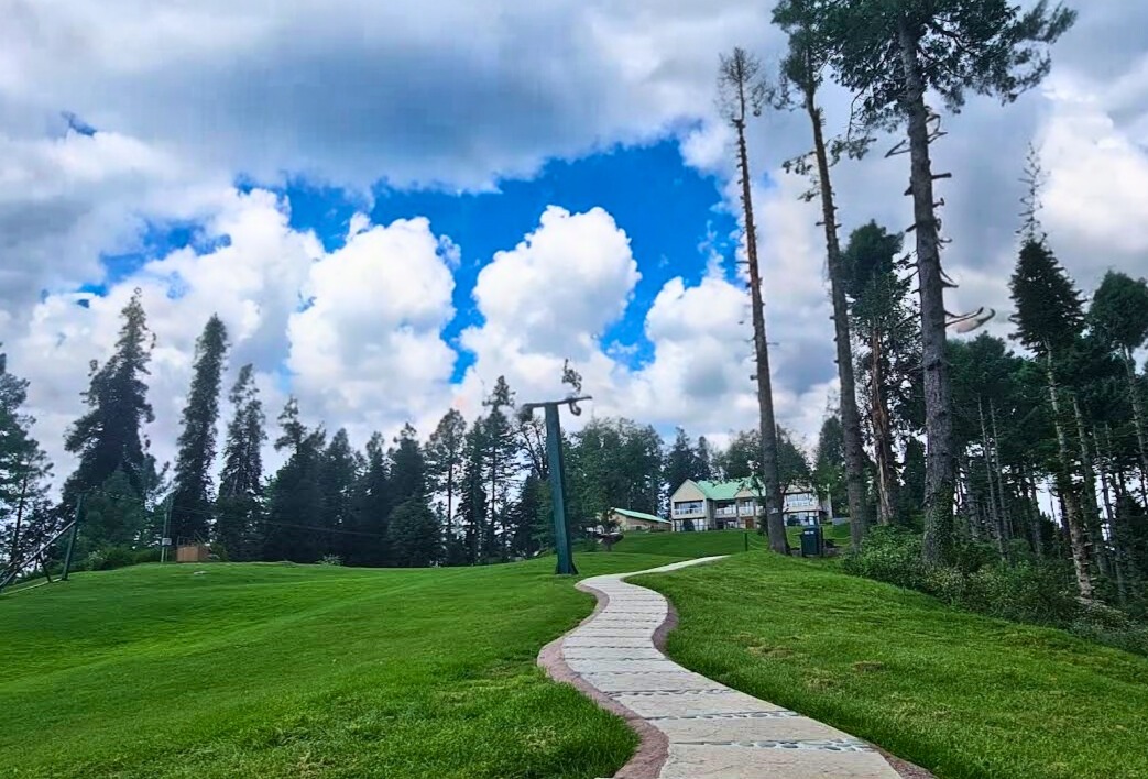 a path leading to a grassy field with a path leading to a house at greenspot nathiagali 