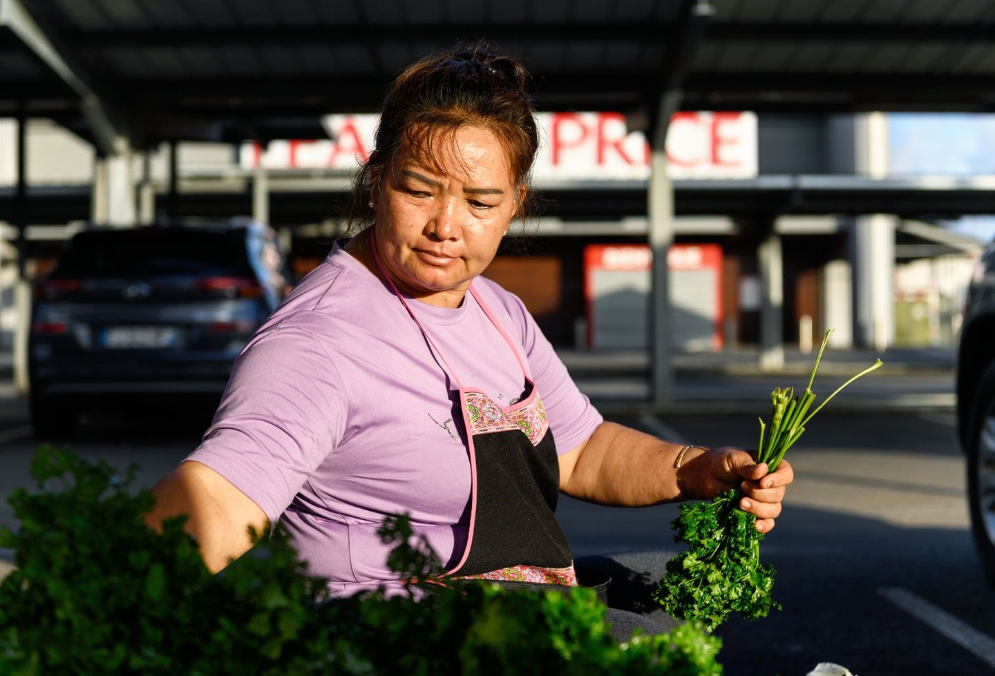 Une femme asiatique prépare ses légumes au marché