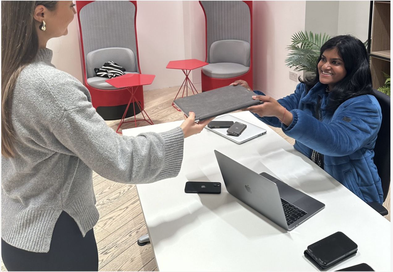 A customer hands a laptop to a member of our team at a TTB CircularIT tech amnesty event