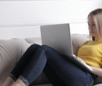 Businesswoman writing on PC on a couch