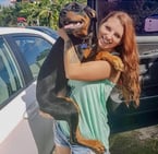 a woman holding a dog in her arms