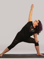 rachel in yoga pose, black outfit purple hair white background