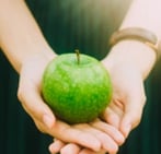 Femme soutenant une pomme verte