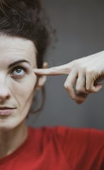 woman pointing to her head
