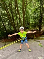 A happy kid learns how to be lowered down