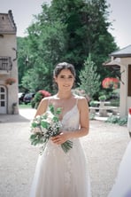 jeune mariée brune tenant un bouquet de fleurs