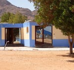 Our studio blue building with a mountain in the background