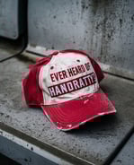 a red and white cap with the inscription “ever heard of handratty?”