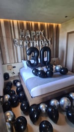 Elegant black and silver balloons decorating a room for a luxurious 30th birthday surprise.