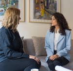 two women sitting on a couch in a living room