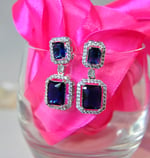 a pair of earrings with blue sapphires and diamonds